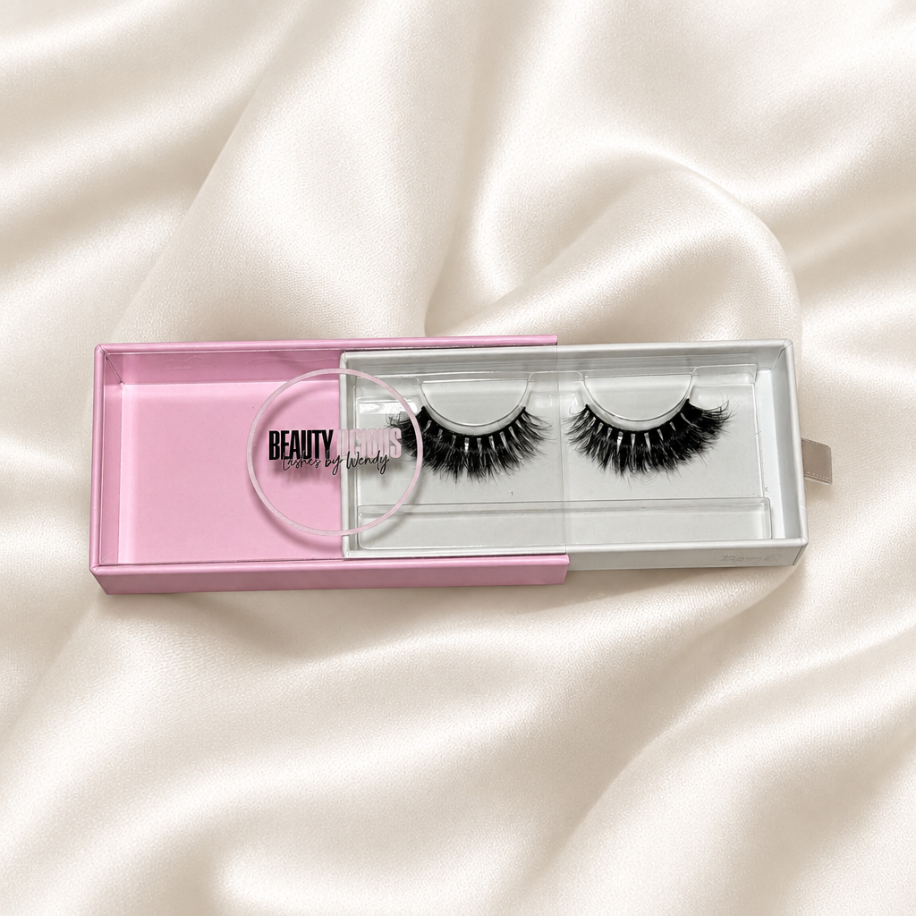 Bambi lashes in pink packaging on an ivory satin background