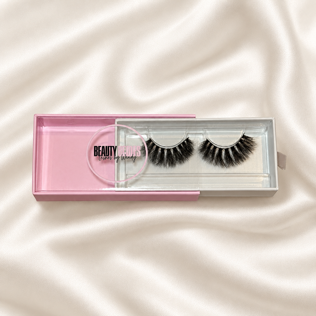 Bombshell faux lashes in pink packaging on soft ivory satin