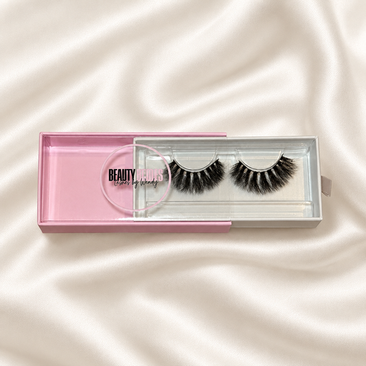 Bombshell faux lashes in pink packaging on soft ivory satin