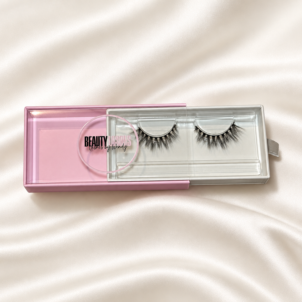 Adore lashes in pink packaging on a soft ivory satin background
