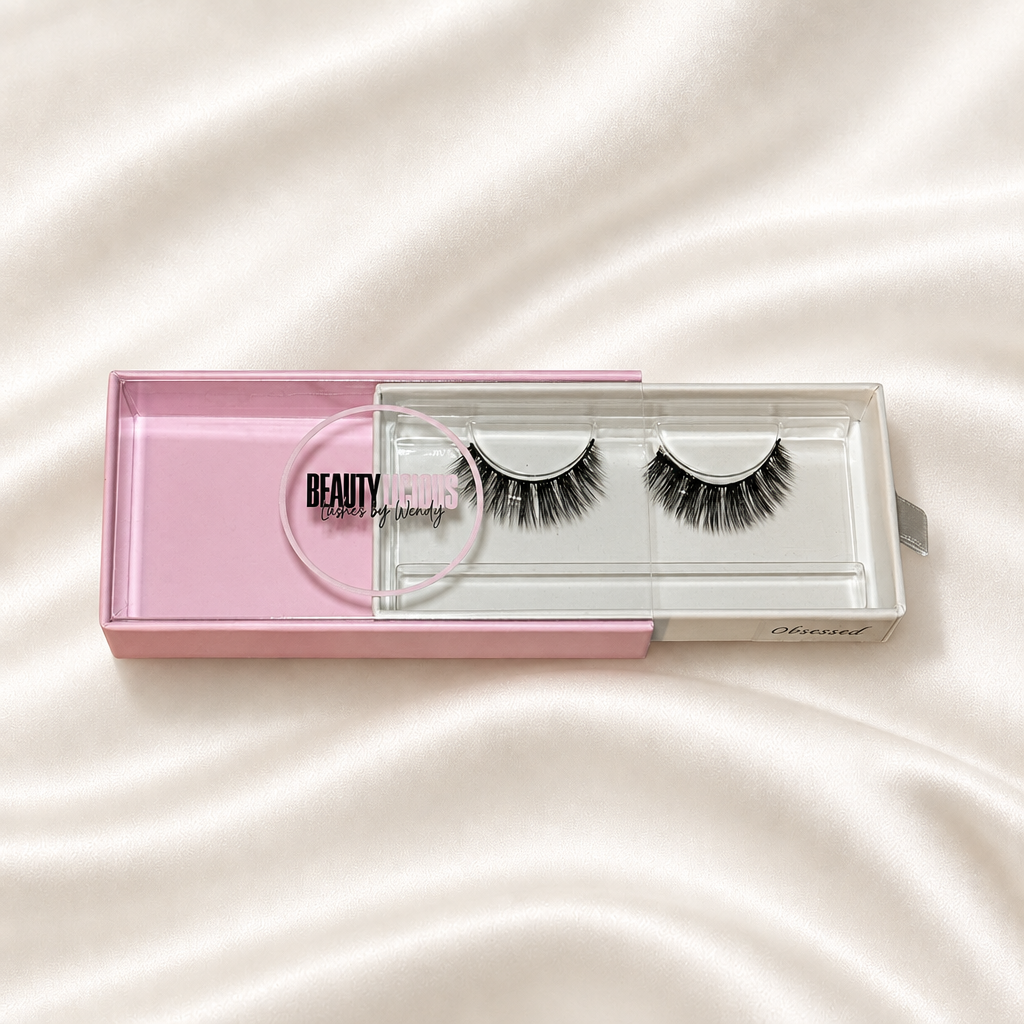 Obessed faux lashes in pink packaging on soft ivory satin