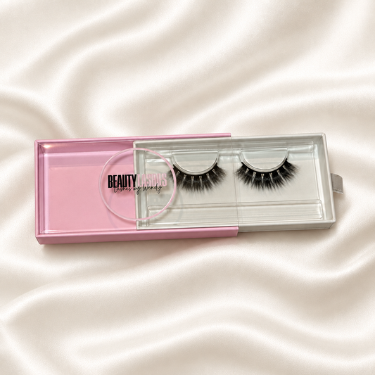 Karma faux lashes in pink packaging on soft ivory satin