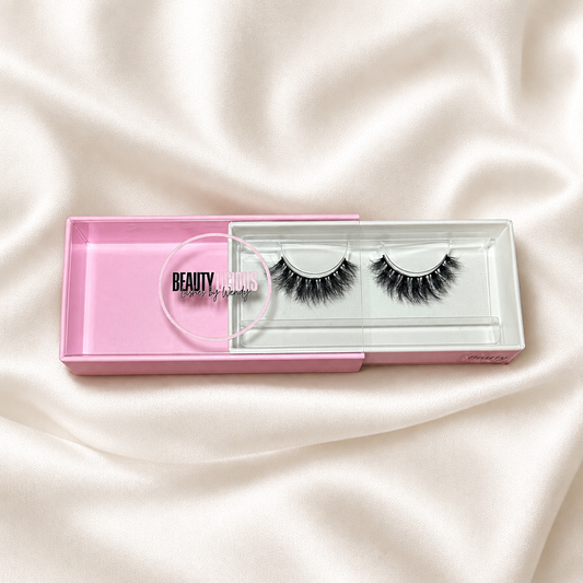 Bratty faux lashes in pink packaging on soft ivory satin