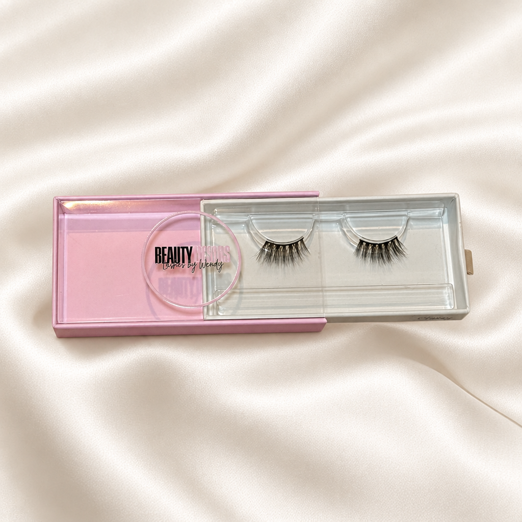 Classy faux lashes in pink packaging on soft ivory satin