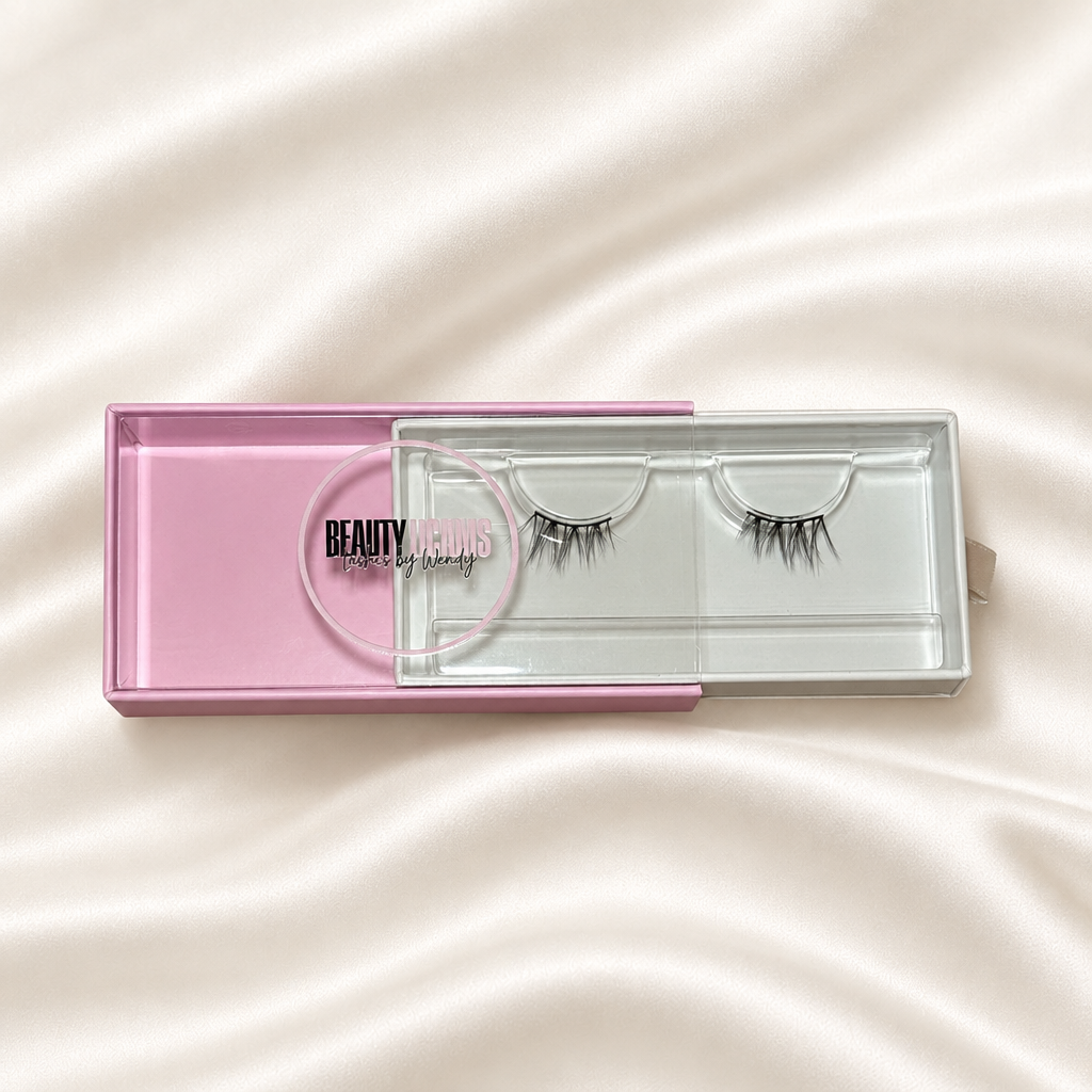 Fantasy faux lashes in pink packaging on soft ivory satin