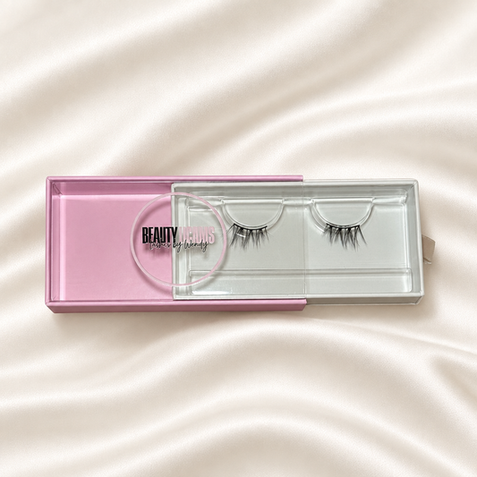 Fantasy faux lashes in pink packaging on soft ivory satin