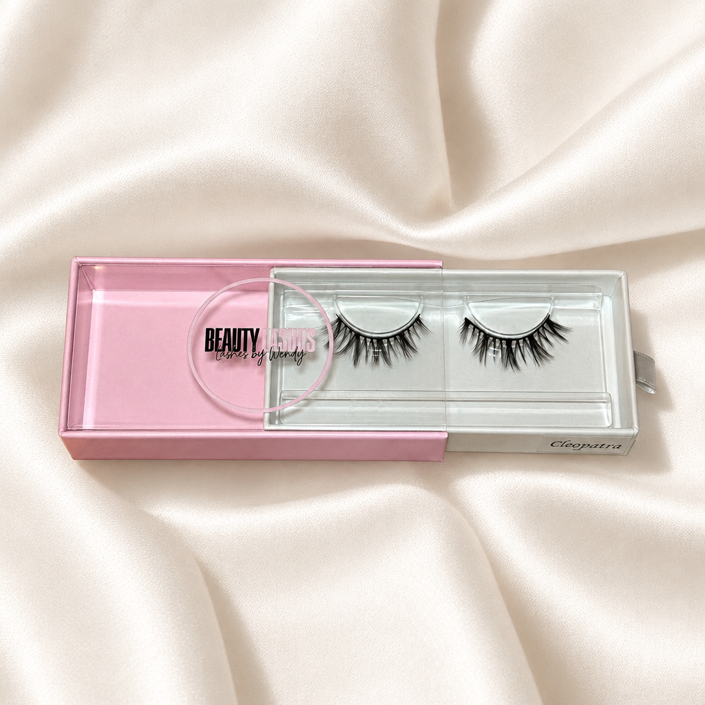Cleopatra faux lashes in pink packaging on soft ivory satin