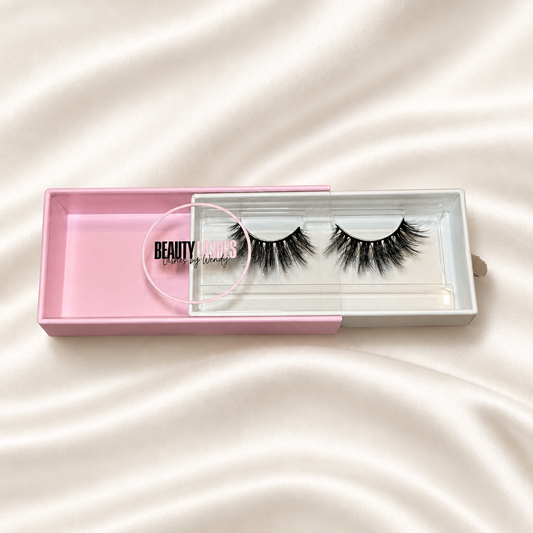 Sexy faux lashes in pink packaging on soft ivory satin