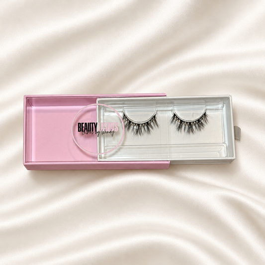 Tesoro Mio faux lashes in pink packaging on soft ivory satin
