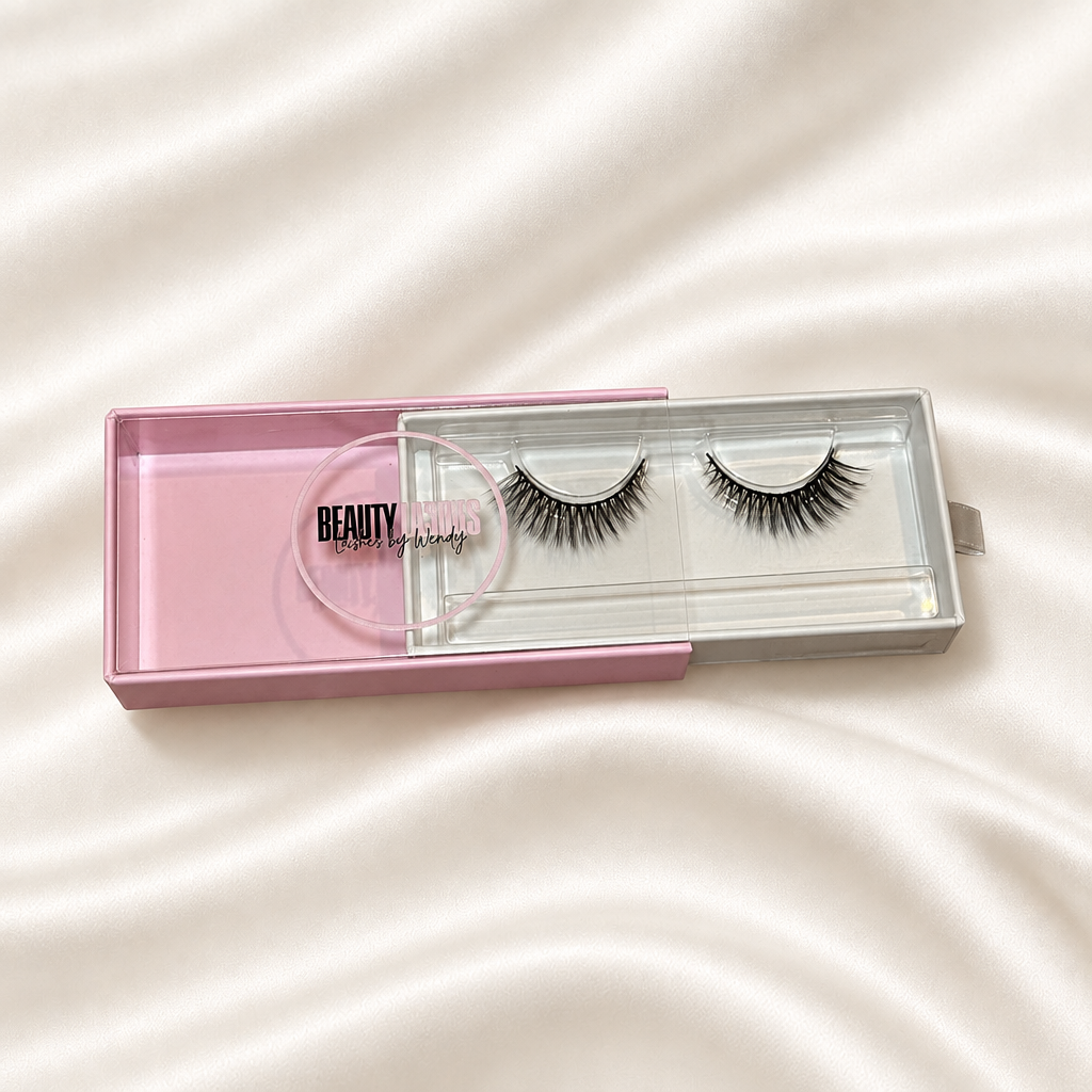 Sophiscated faux lashes in pink packaging on soft ivory satin