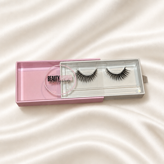 Sophiscated faux lashes in pink packaging on soft ivory satin