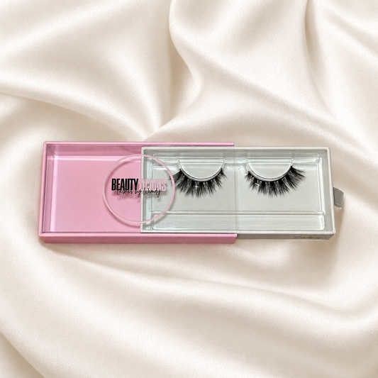 Bunny faux lashes in pink packaging on soft ivory satin