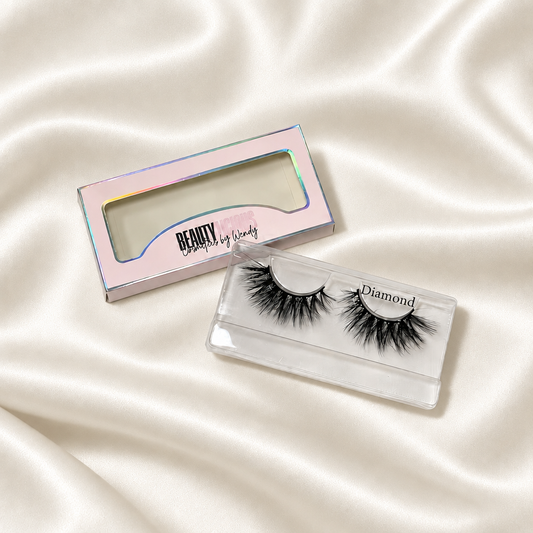 Diamond faux lashes and Beautylicious packaging on soft ivory satin